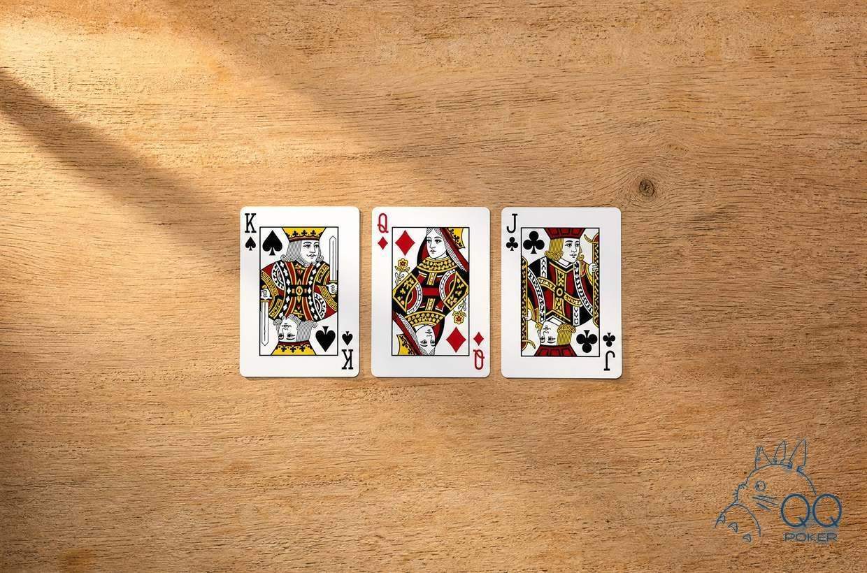 浅木桌面上横排的三张公共牌：K♠、Q♦、J♣